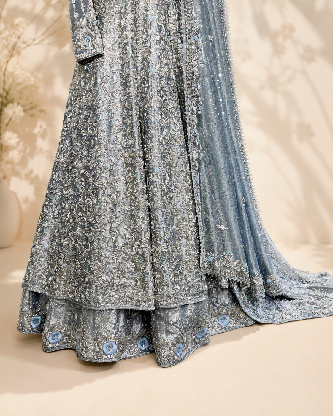 Hem detail of the Sapphire bridal set showing the double-layered scalloped skirt with pale blue floral motifs and silver embroidery