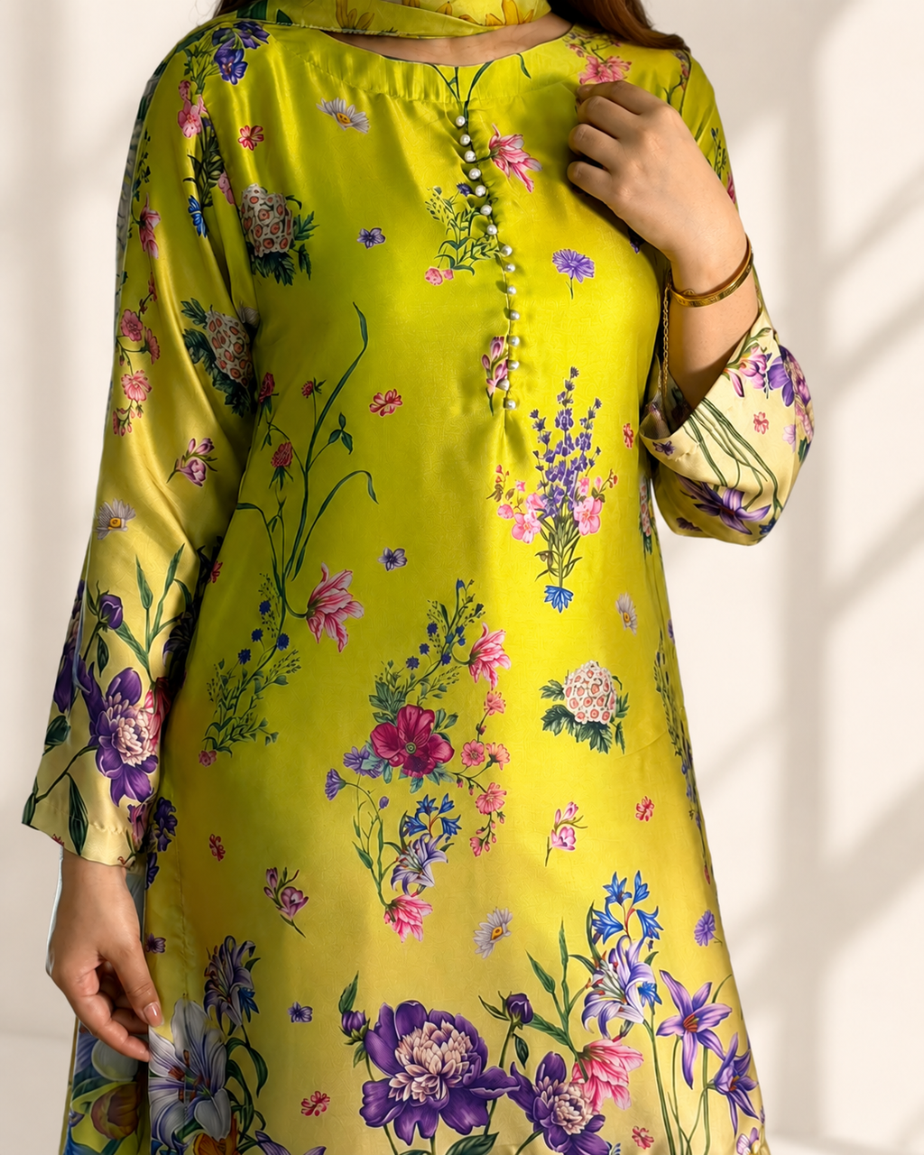 Close-up of the lime floral print and pearl-button placket on the kameez